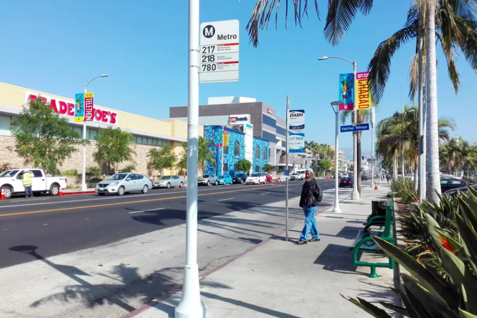 Sidewalk bus stop with bench and no shade in Los Angeles, California
